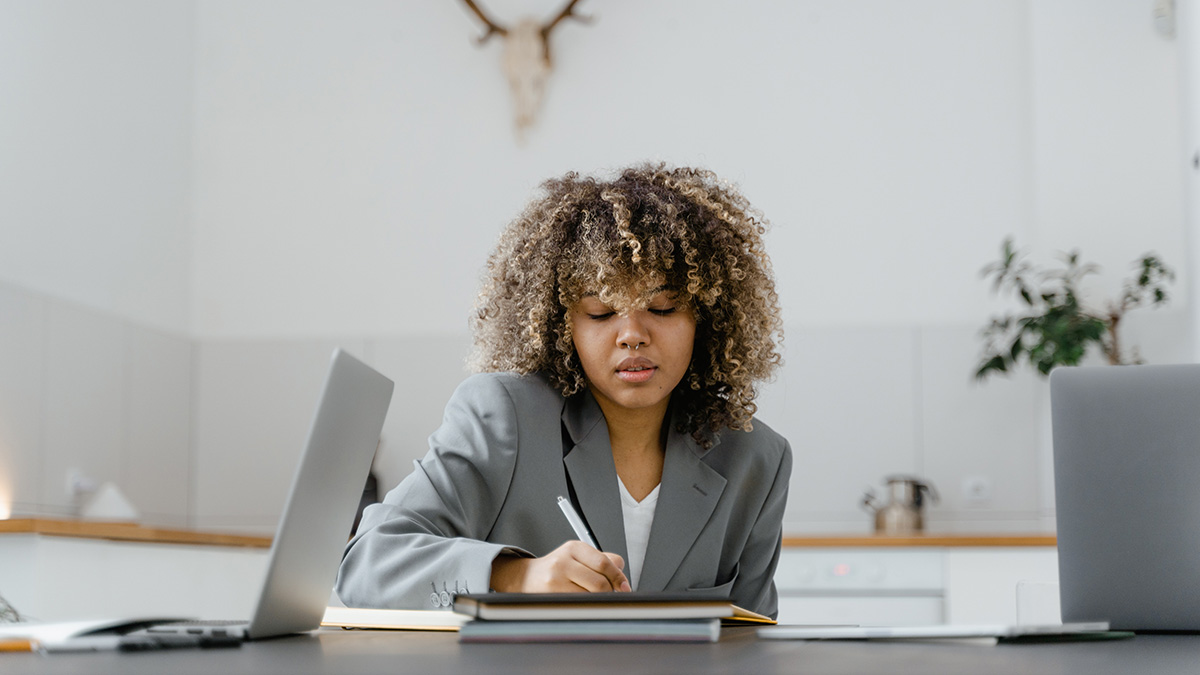 Frau am Tisch arbeitend am Laptop