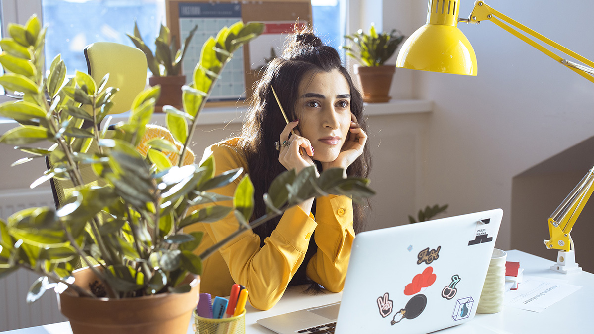 Frau, die nachdenklich am Laptop sitzt